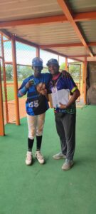 Osiris Reynoso Ceo de BplBeisbol premia a Cristopher Martinez de la academia de Paulino quien resulto el MVP.